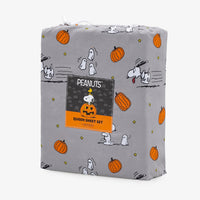 A gray Peanuts-themed Halloween queen sheet set with a printed pattern of Snoopy, Woodstock, pumpkins, ghosts, and stars, featuring a central Peanuts brand label.