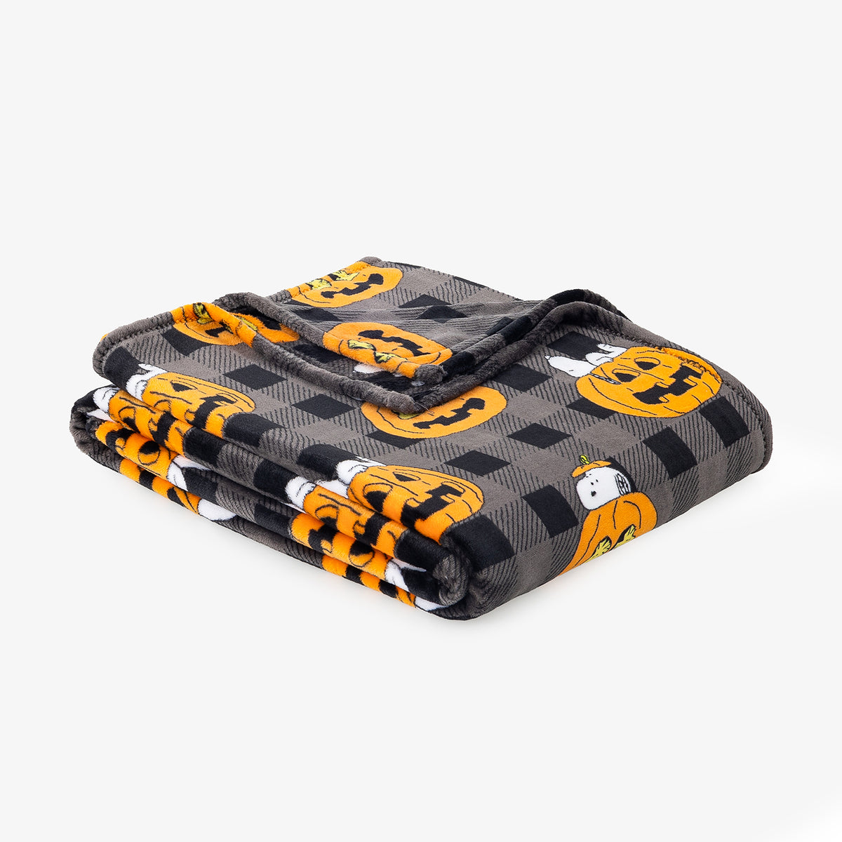 A folded blanket featuring a black and gray buffalo plaid pattern with orange jack-o'-lantern pumpkins and small white ghosts, set against a plain light gray background.