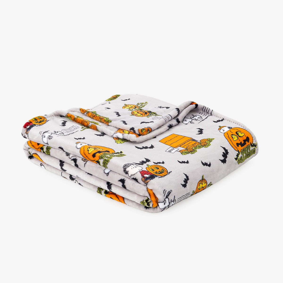 A folded white blanket with a Halloween print featuring orange pumpkins, black bats, ghosts, and a cartoon character, shown on a light gray background.