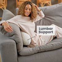 A woman lounging on a neckroll pillow displaying lumbar support functionality.