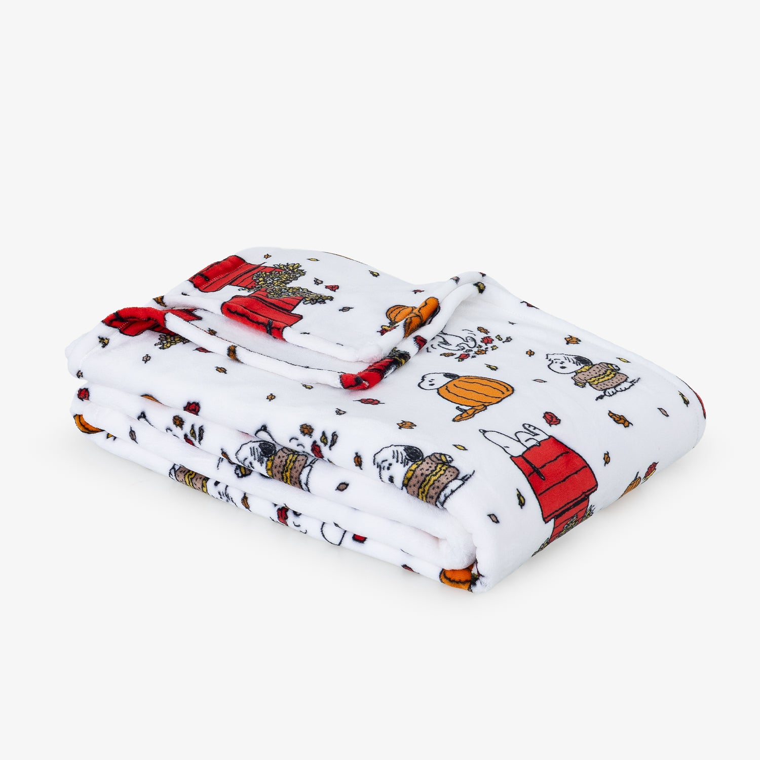 A folded white blanket featuring a colorful cartoon print of Snoopy and his doghouse, displayed on a clean white background.