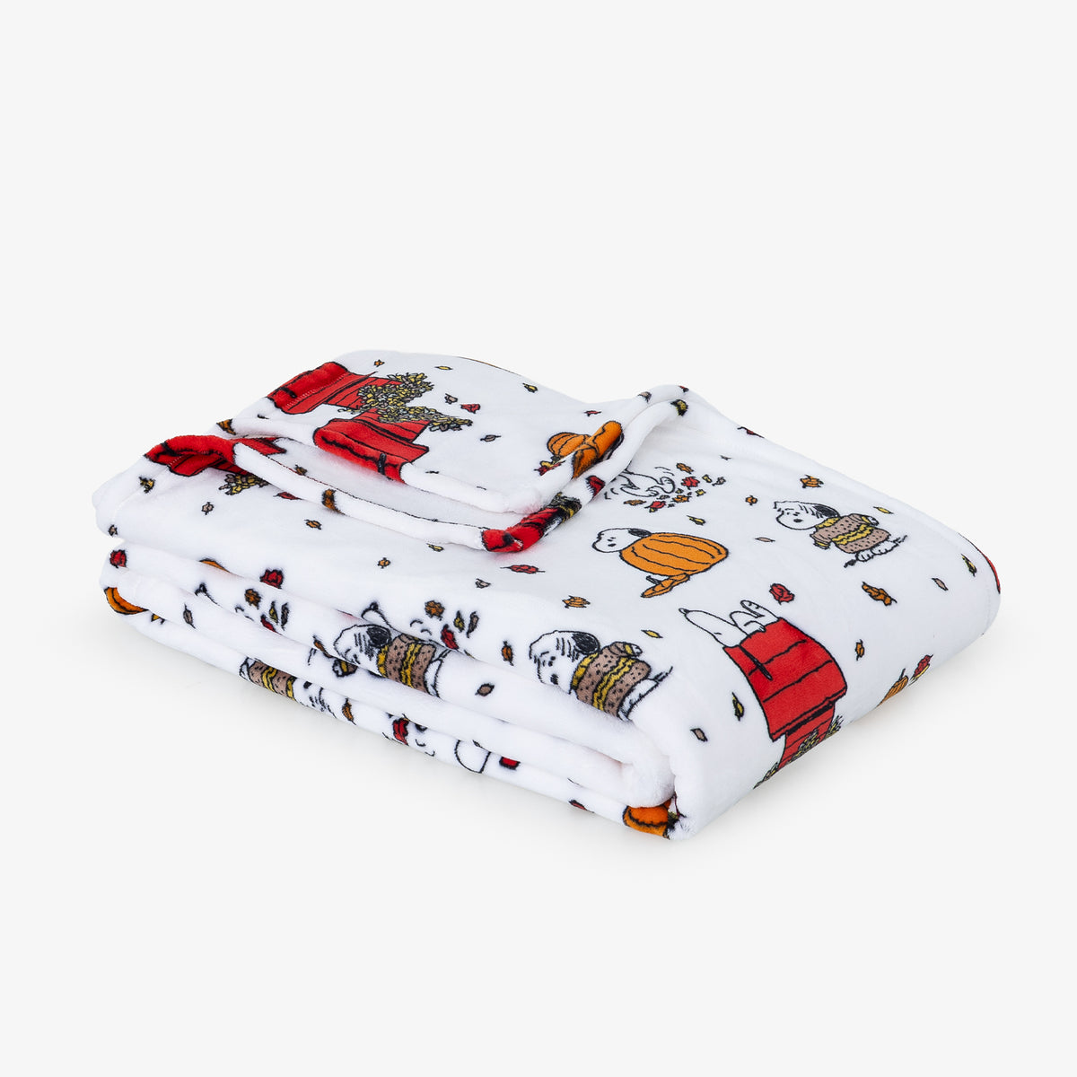 A folded white blanket featuring a colorful cartoon print of Snoopy and his doghouse, displayed on a clean white background.