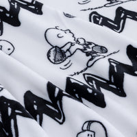 Close-up of a white fabric with a black cartoon print featuring Snoopy and a zigzag pattern.