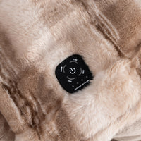 Close up of a textured faux fur heated throw and its EZ touch heat setting button.
