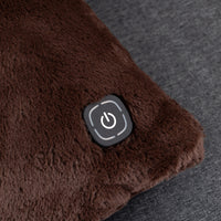 Close-up of a brown plush heated cushion with a black power button on a dark gray textured fabric background.