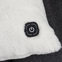 Close-up of a white sherpa or faux-fur cushion with a black square power button on the front, set against a dark gray textured fabric background.