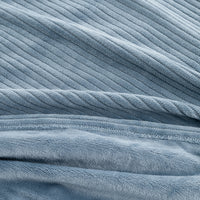 A close-up of a dusty blue ribbed fabric, showing the textured corduroy-like vertical ridges and soft plush terry-like lower section.