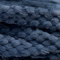 Close up of a textured blue faux fur heated throw.