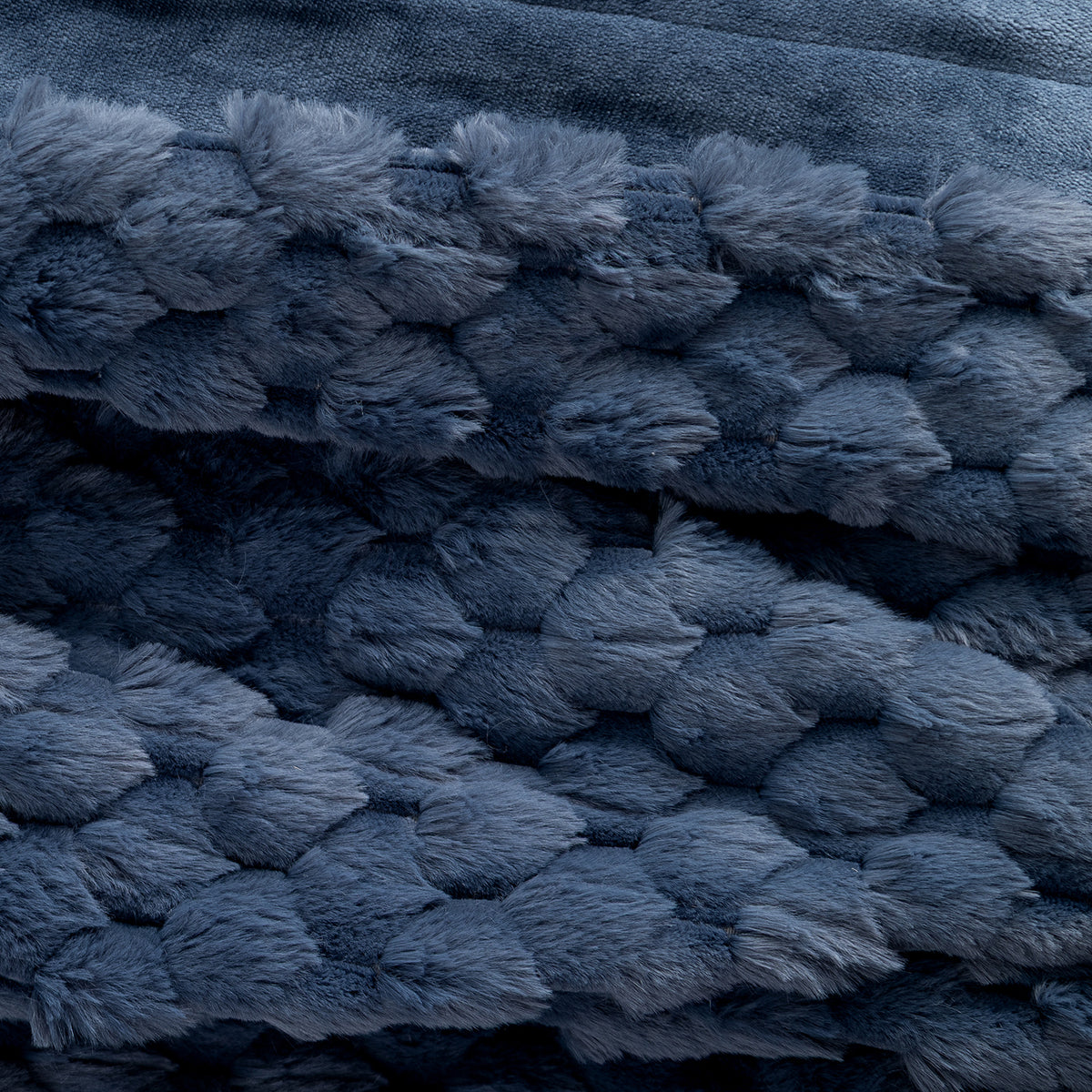 Close up of a textured blue faux fur heated throw.
