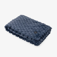 A folded navy blue textured throw blanket with a chunky braided pattern and fringed edges, shown on a clean white background.