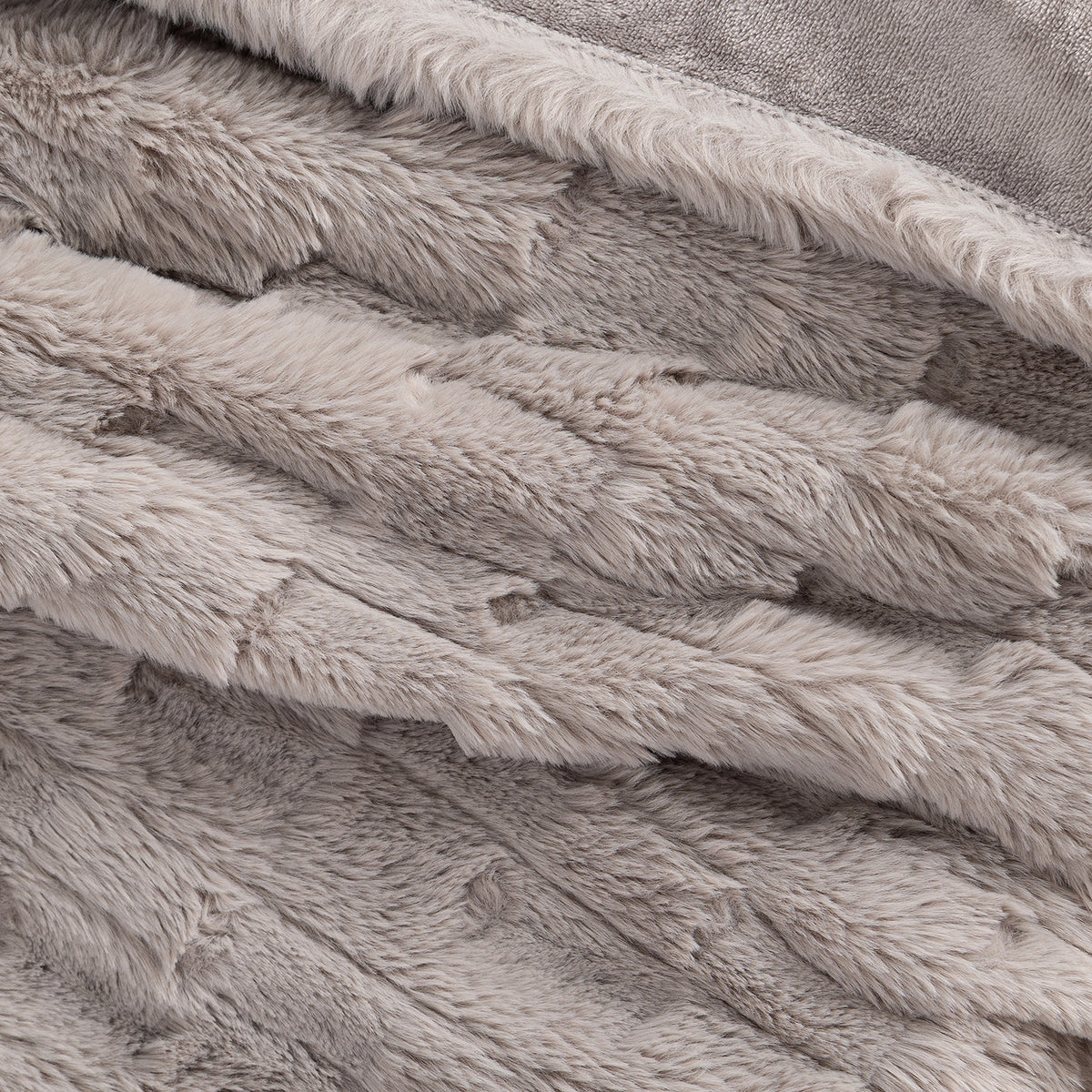 Close up of a taupe plush faux fur texted heated throw.