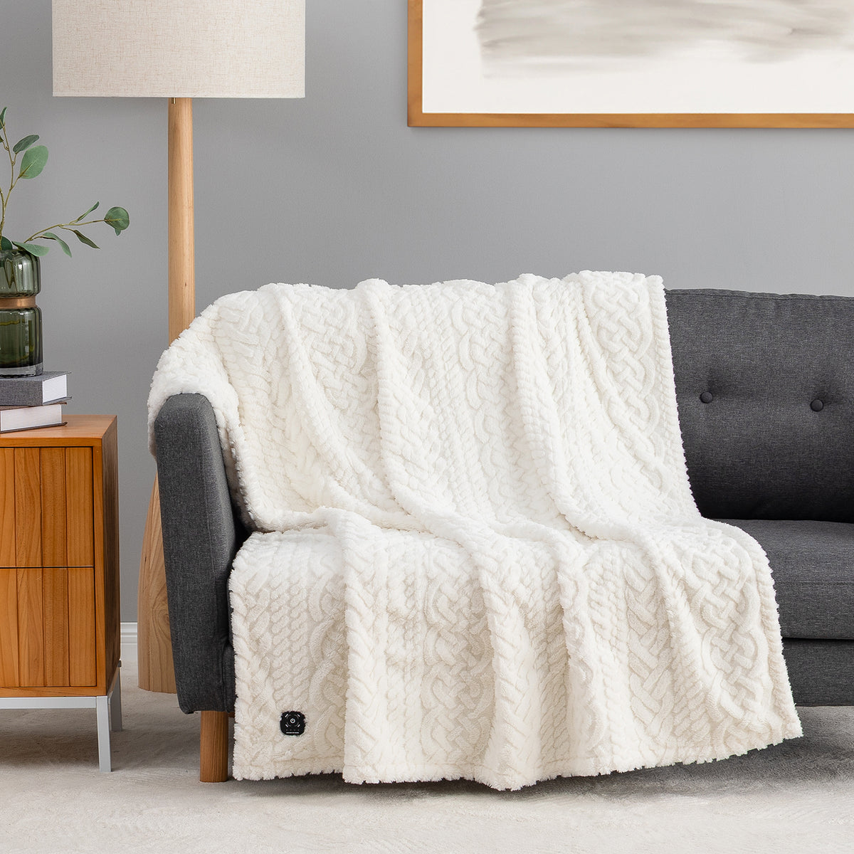 Cream colored faux fur heated throw draped over a chair.