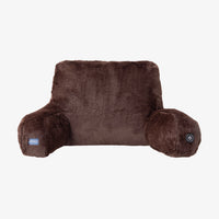 A brown plush heated pillow cushion with a small blue brand tag on the left armrest and a power button on the right armrest, shown against a plain white background.
