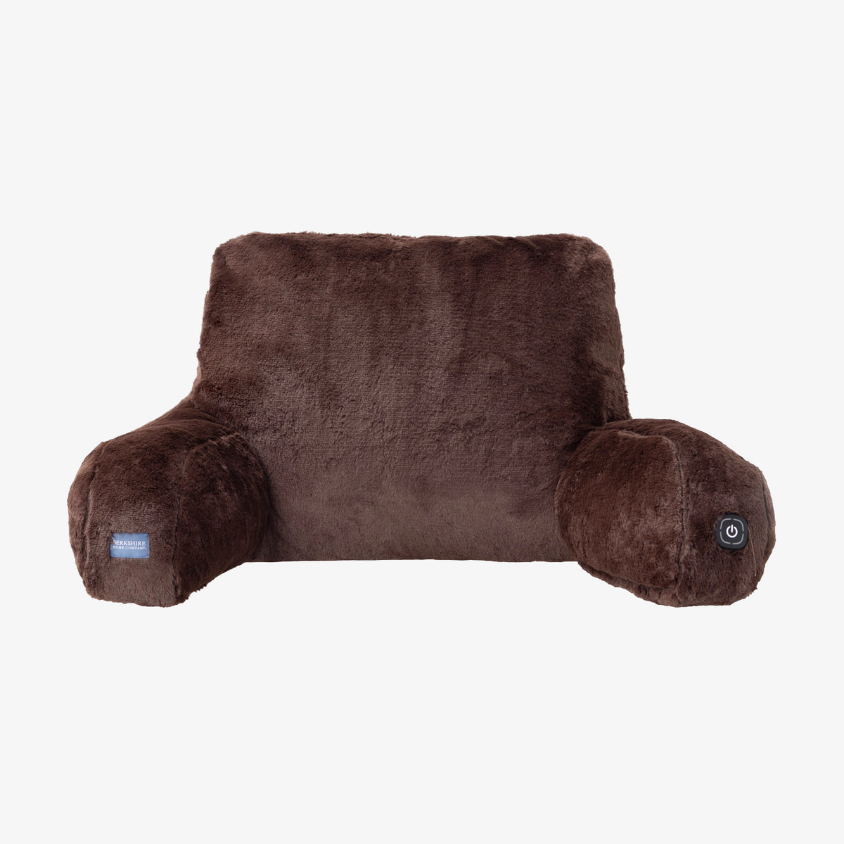 A brown plush heated pillow cushion with a small blue brand tag on the left armrest and a power button on the right armrest, shown against a plain white background.