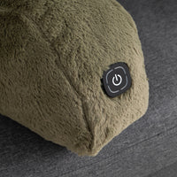 Close-up of a plush, textured olive green heated pillow or cushion with a black power button on the side, resting on a gray fabric surface.