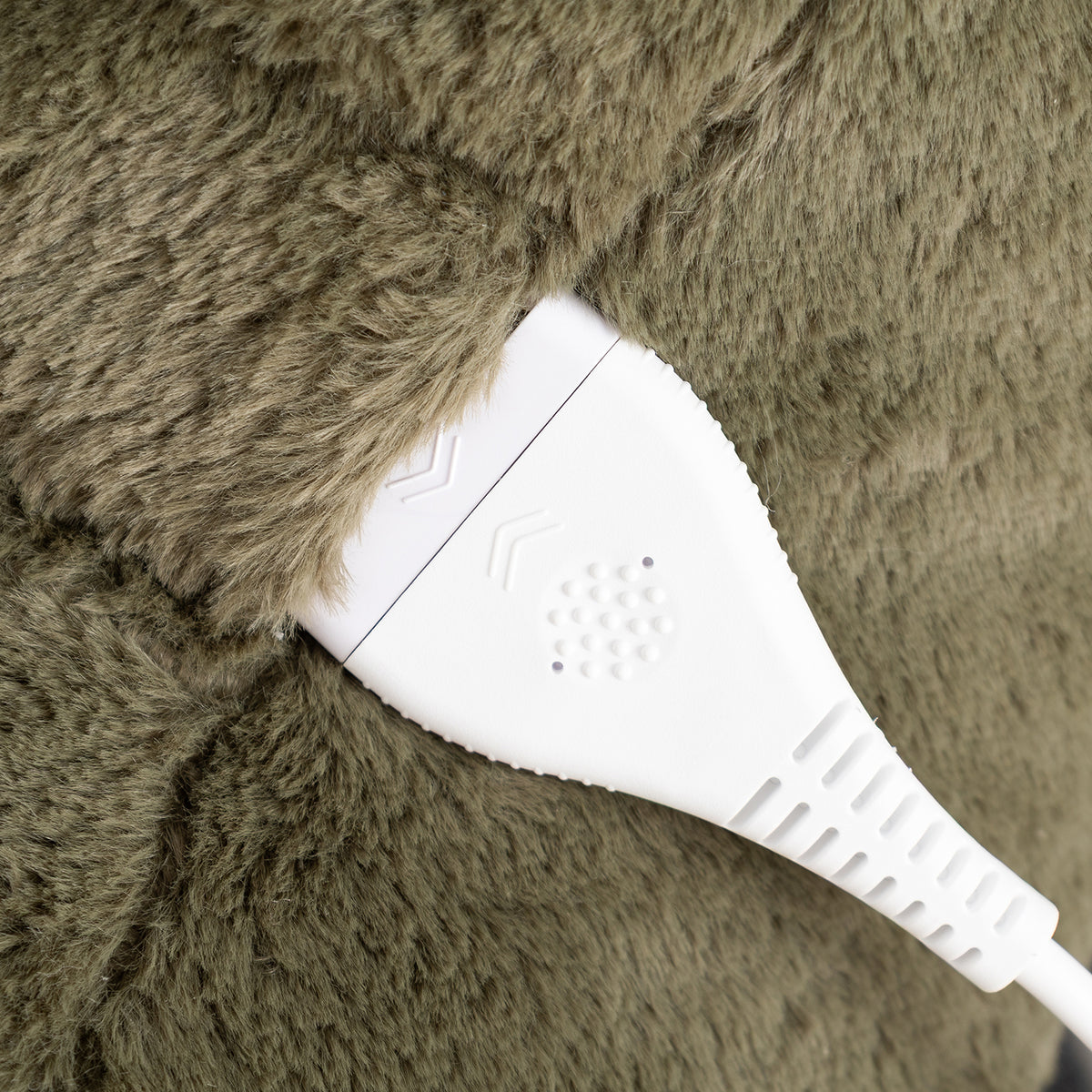 Close-up of a white electronic control module attached to a brown faux fur surface.