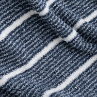 A close-up of a textured fabric with a diagonal striped pattern in navy blue and white.
