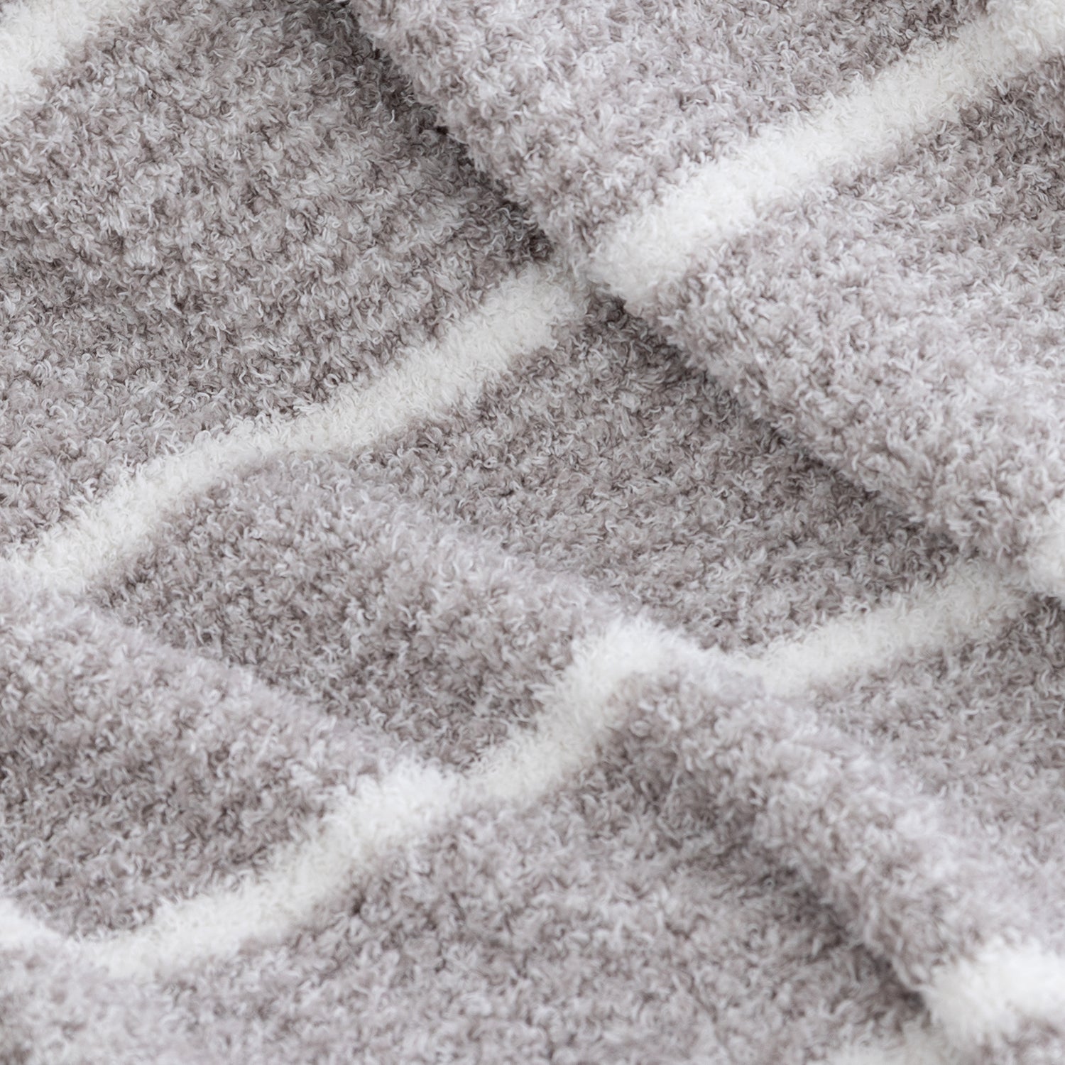 Close-up of a plush, textured fabric with a gray and white striped pattern.