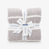 Two folded textured knit blankets in a heathered light gray and white stripe pattern, tied together with a white ribbon and paper tag from Bernsiere.