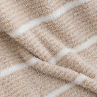 Close-up of a plush, textured fabric with a striped pattern in warm beige and off-white.