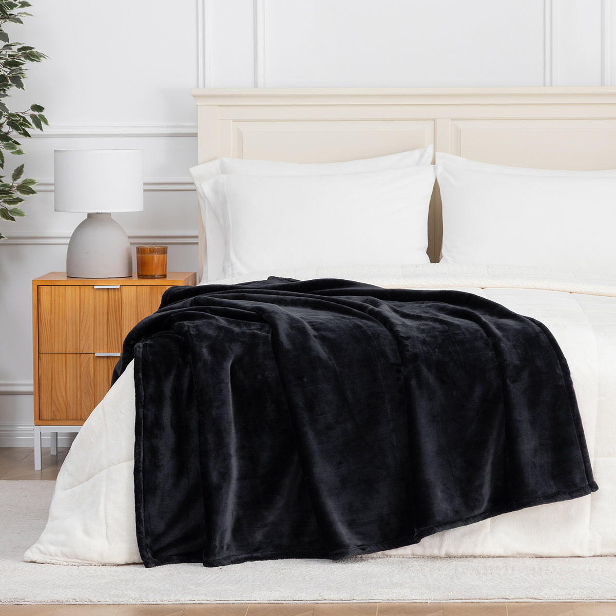 Premium VelvetLoft® Throw in Black, draped across the foot of a bed