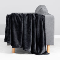 Premium VelvetLoft® Throw in Black, draped over the arm of a gray sofa, close view