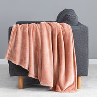 Premium VelvetLoft® Throw in Cafe Blush, draped over the arm of a gray sofa, close view