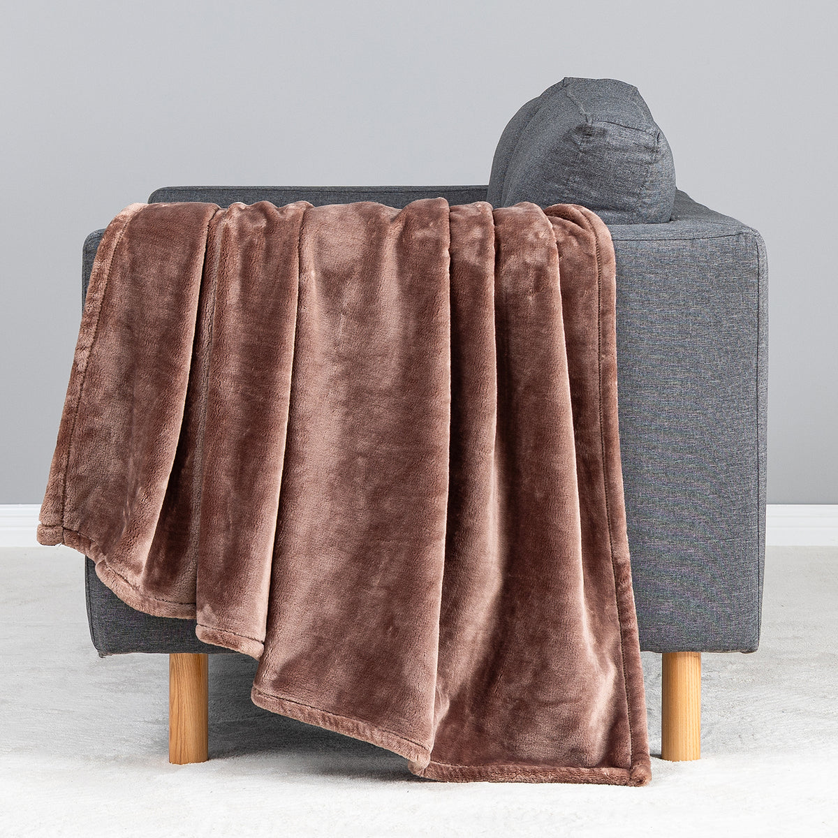 Premium VelvetLoft® Throw in Hazel, draped over the arm of a gray sofa, close view