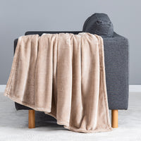 Premium VelvetLoft® Throw in Hummus, draped over the arm of a gray sofa, close view