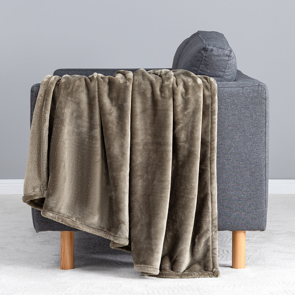 Premium VelvetLoft® Throw in Kalamata, draped over the arm of a gray sofa, close view