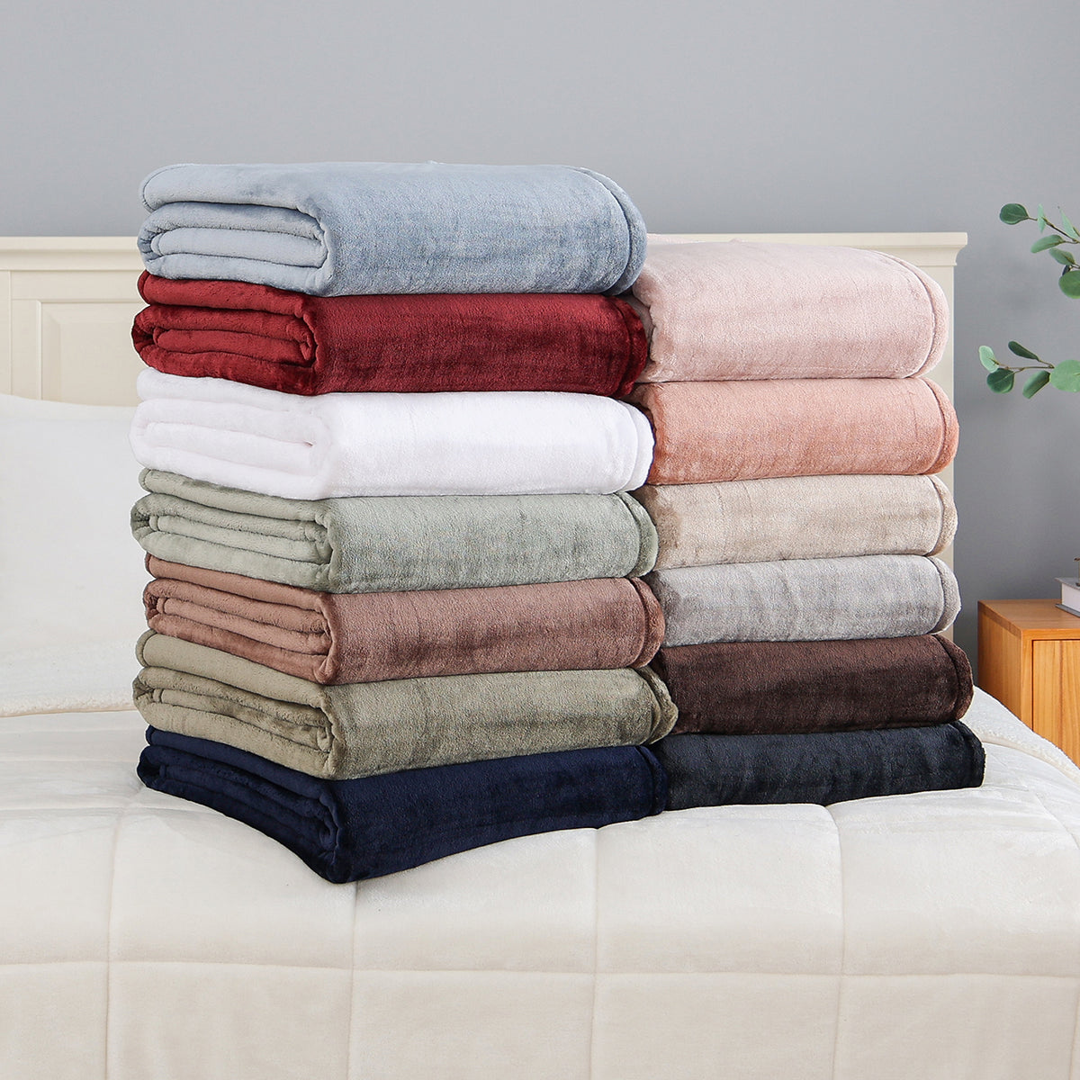 Folded Premium VelvetLoft® Throws in assorted Colors stacked on a bed