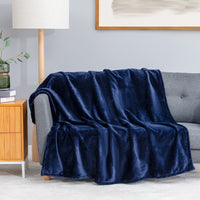 Premium VelvetLoft® Throw in Midnight Blue, draped over a gray sofa in a living room