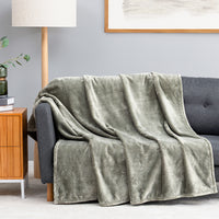 Premium VelvetLoft® Throw in Olive Shadow, draped over a gray sofa in a living room