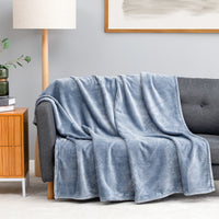 Premium VelvetLoft® Throw in Polar Blue, draped over a gray sofa in a living room