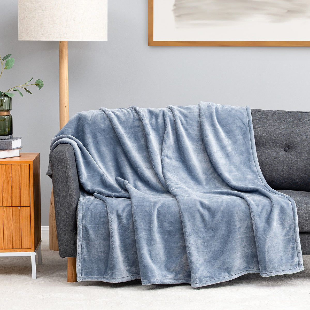 Premium VelvetLoft® Throw in Polar Blue, draped over a gray sofa in a living room