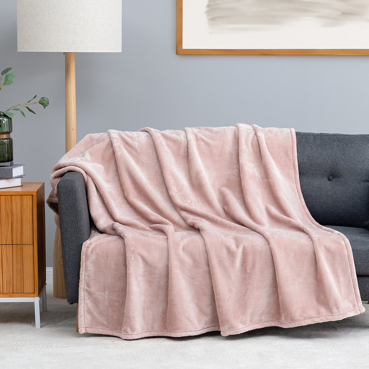 Premium VelvetLoft® Throw in Rose Smoke, draped over a gray sofa in a living room