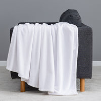 Premium VelvetLoft® Throw in True White, draped over the arm of a gray sofa, close view