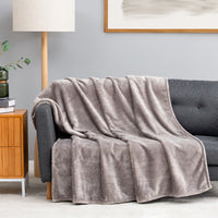 Premium VelvetLoft® Throw in Wild Dove, draped over a gray sofa in a living room