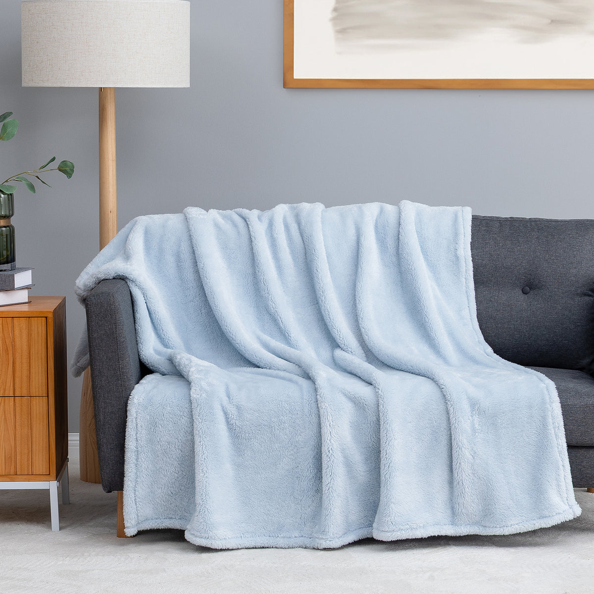 Premium Extra-Fluffy™ Throw in Arctic Blue draped over a gray sofa in a living room