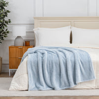 Premium Extra-Fluffy™ Throw in Arctic Blue draped across the foot of a bed