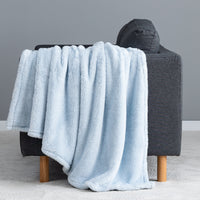 Premium Extra-Fluffy™ Throw in Arctic Blue draped over the arm of a gray sofa, close view