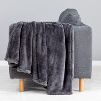 Premium Extra-Fluffy™ Throw in Castle Rock draped over the arm of a gray sofa, close view
