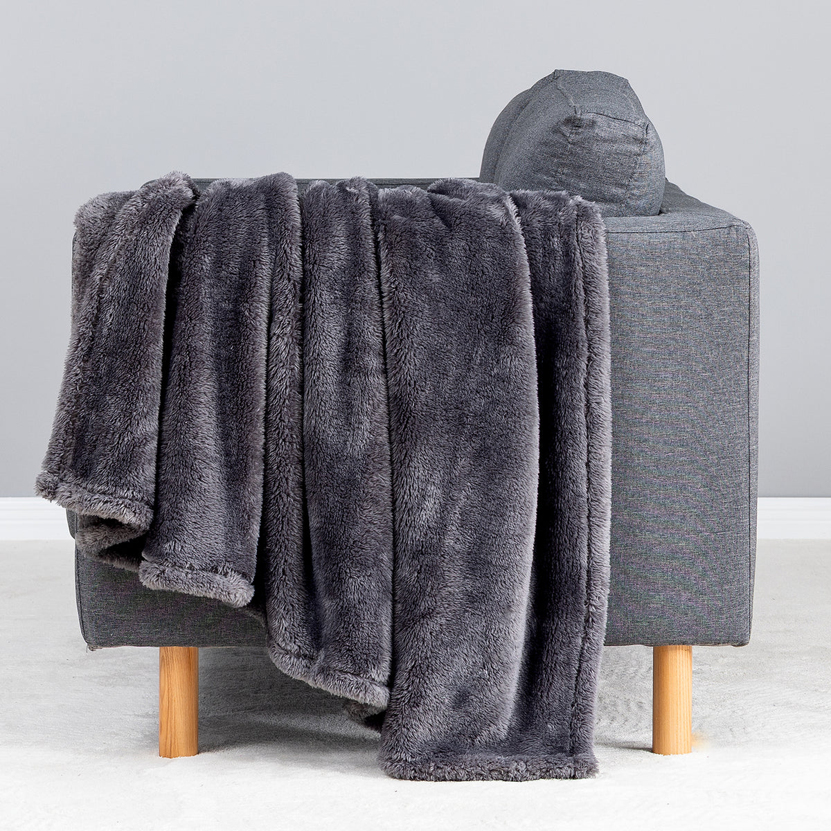 Premium Extra-Fluffy™ Throw in Castle Rock draped over the arm of a gray sofa, close view