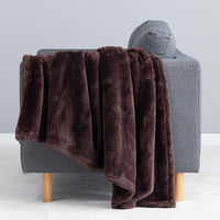 Premium Extra-Fluffy™ Throw in Coffee Brown draped over the arm of a gray sofa, close view