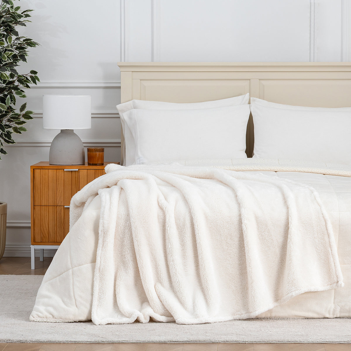 Premium Extra-Fluffy™ Throw in Cream draped across the foot of a bed