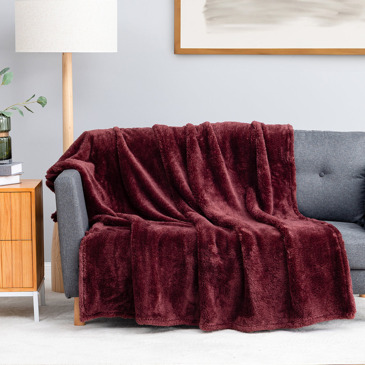 Premium Extra-Fluffy™ Throw in Deep Fig draped over a gray sofa in a living room