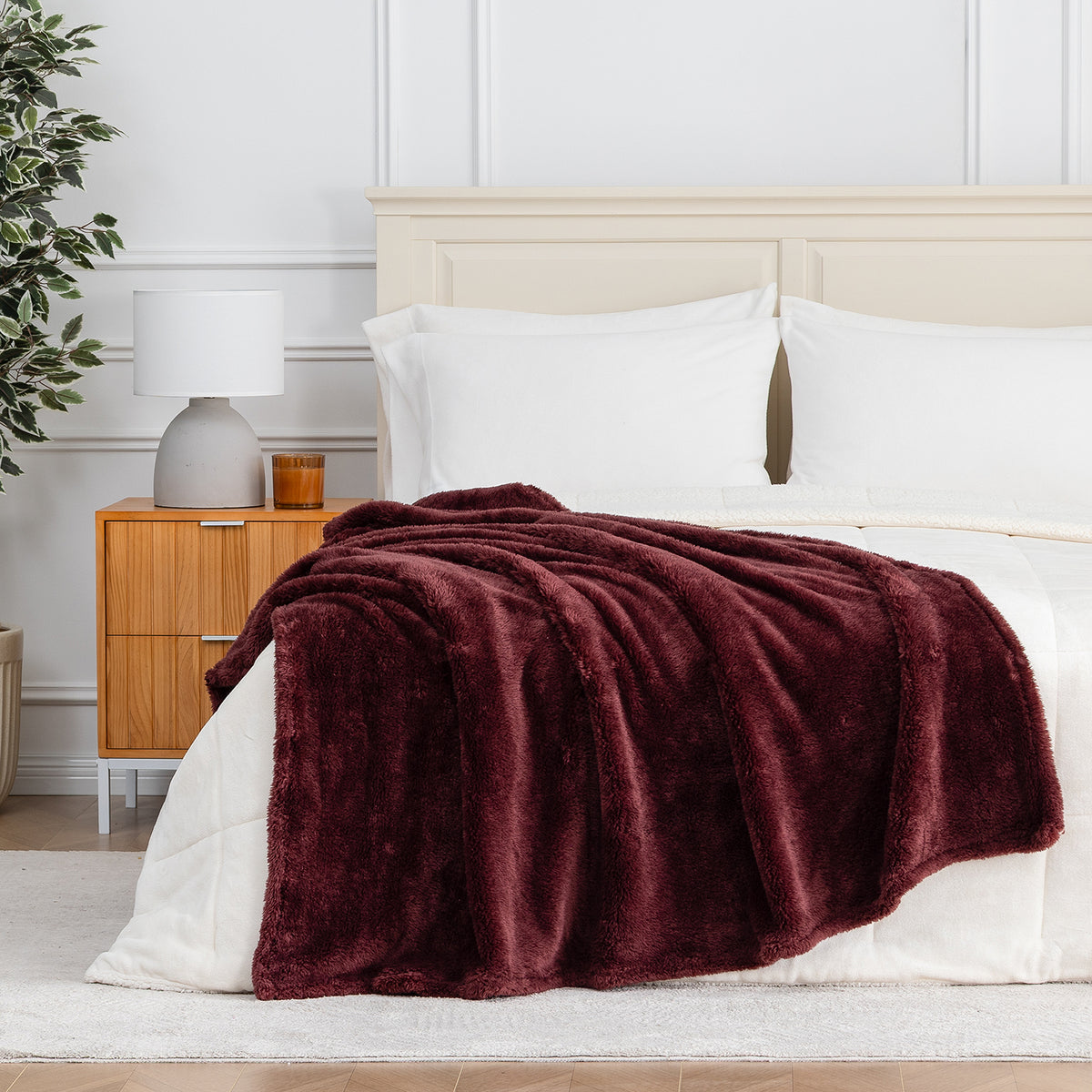 Premium Extra-Fluffy™ Throw in Deep Fig draped across the foot of a bed