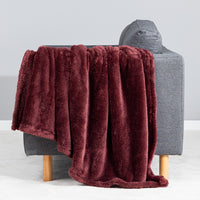 Premium Extra-Fluffy™ Throw in Deep Fig draped over the arm of a gray sofa, close view