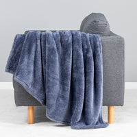 Premium Extra-Fluffy™ Throw in Galaxy Blue draped over the arm of a gray sofa, close view
