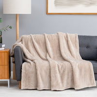 Premium Extra-Fluffy™ Throw in Grain draped over a gray sofa in a living room